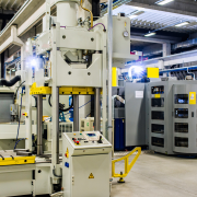 A large CNC machine surrounded by various smaller machines in a busy factory setting