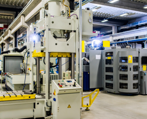 A large CNC machine surrounded by various smaller machines in a busy factory setting