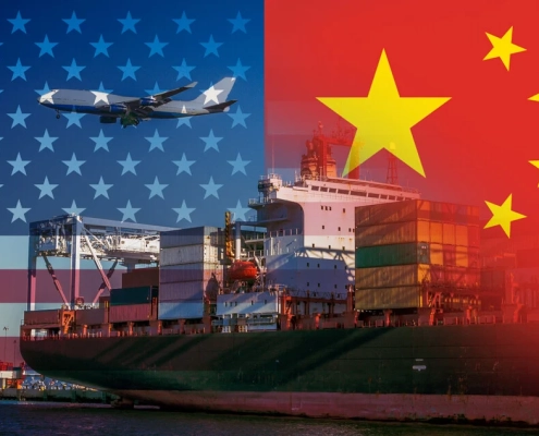 US and China flags in the background of container ships