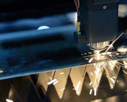 laser cutting machine slices through metal with a focused beam in a fabrication shop