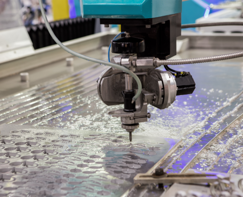 A metal cutting CNC machine accurately slices through metal on a table