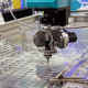A metal cutting CNC machine accurately slices through metal on a table