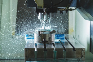 An industrial machine shapes a metal piece, utilizing water in the manufacturing process