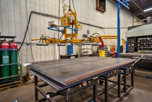 A metal table in a metal shop, featuring a machine for fabrication and assembly tasks