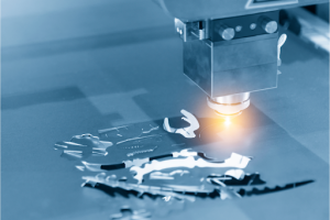 A laser cutter actively cuts a metal sheet, demonstrating precision in manufacturing.