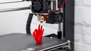 A 3D printer printing a red glove 