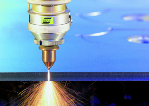 A laser cutting machine produces sparks as it slices through a piece of metal