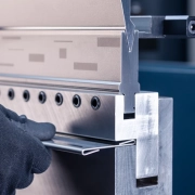 Person using metal cutting tool to slice through metal sheet