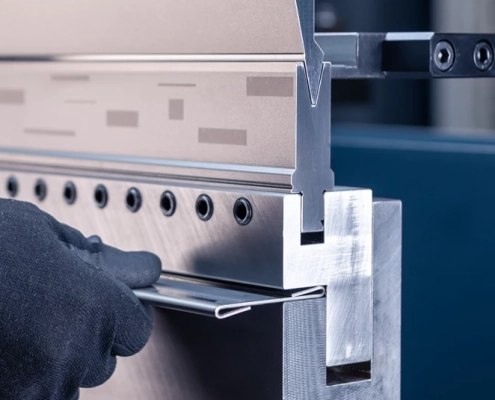 Person using metal cutting tool to slice through metal sheet