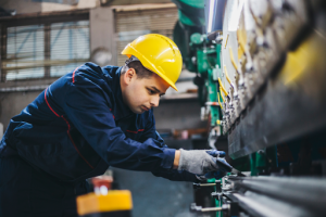 A construction worker in a hard hat operating a piece of machinery