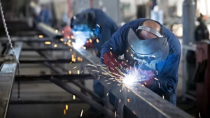 Two welders working on metal components 