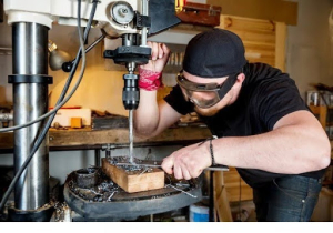 a factory worker handling drilling machine