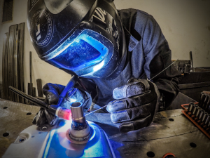 a factory worker fixing metal pipe